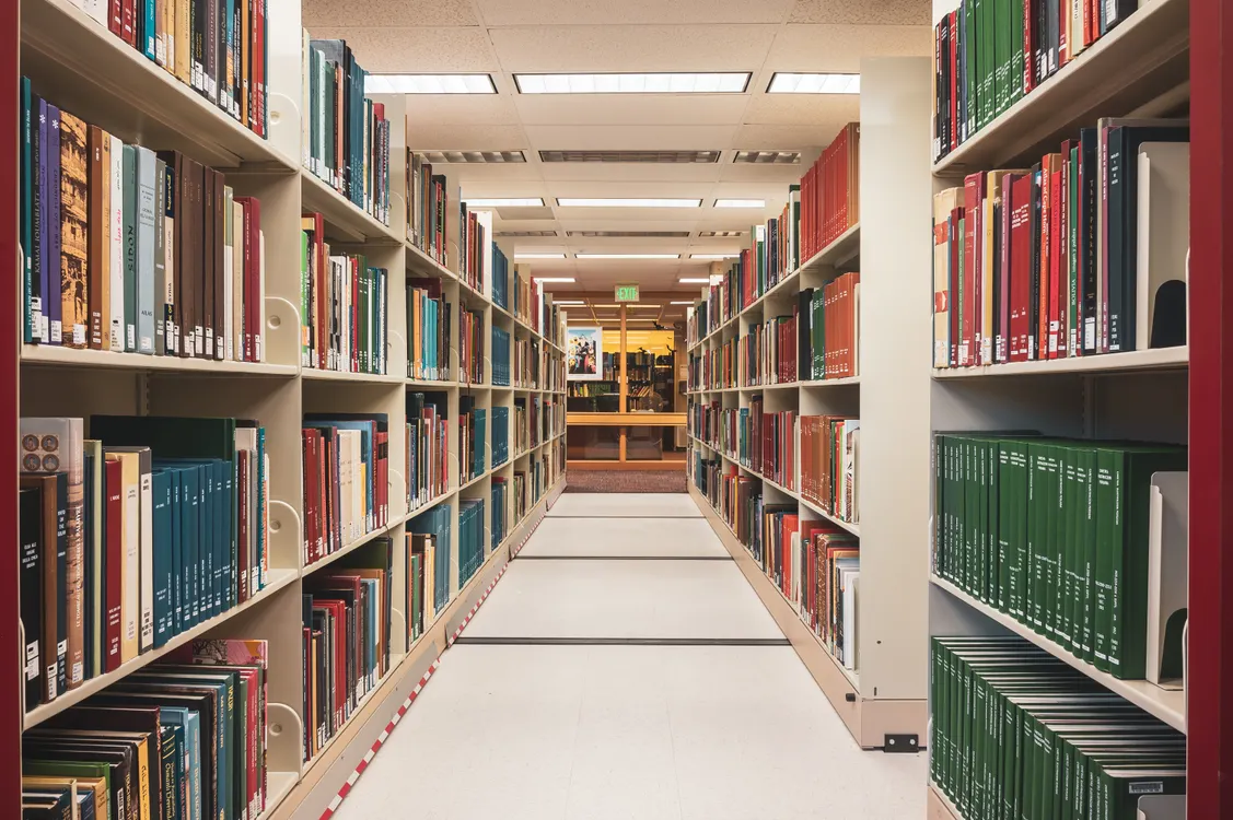 A long aisle of colorful books in a college library